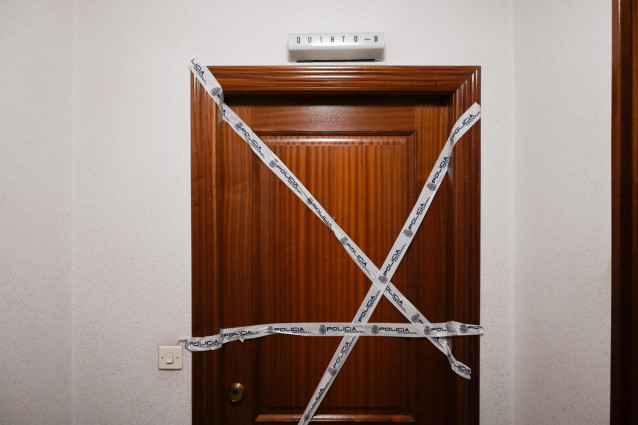 Puerta precintada de la vivienda donde se encontró el cuerpo de una mujer asesinada en A Coruña