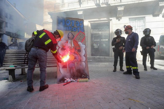 Un hombre prende fuego a una pancarta con un retrato de la ministra de Industria, Reyes Maroto, en una concentración conjunta de trabajadores de las fábricas de Alcoa y de Vestas situadas en A Mariña (Lugo), frente a la Subdelegación del Gobierno, a 10 de