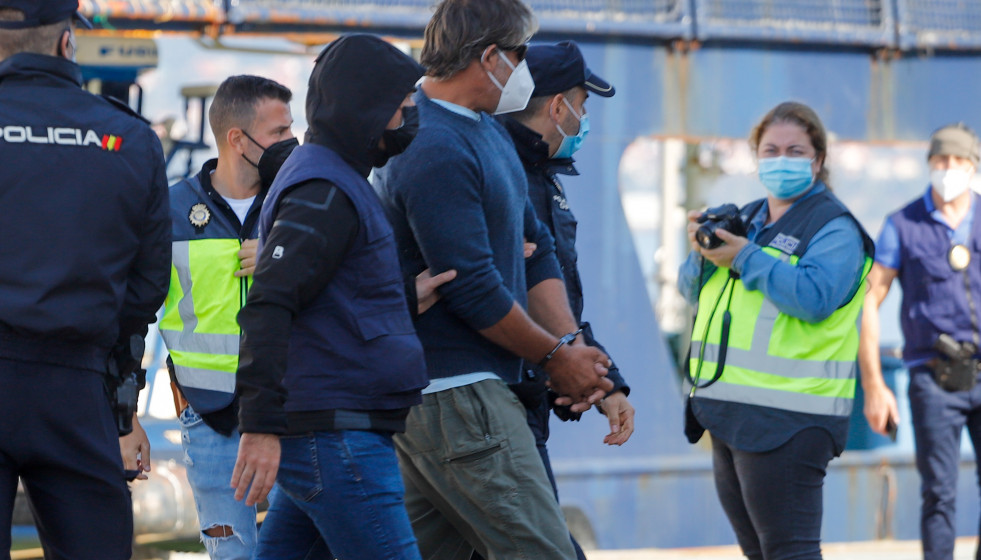 Varios policías acompañan a uno de los detenidos del velero interceptado en aguas del Atlántico norte cargado de cocaína con destino a España, a 15 de octubre de 2021, en Vigo, Pontevedra, Galici