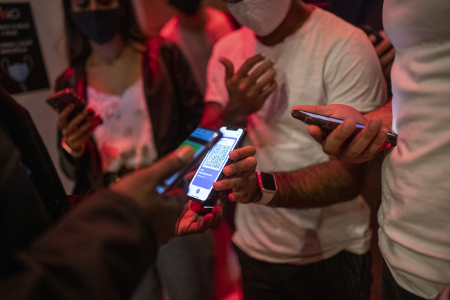 Una persona muestra un código QR para entrar a un local de ocio nocturno