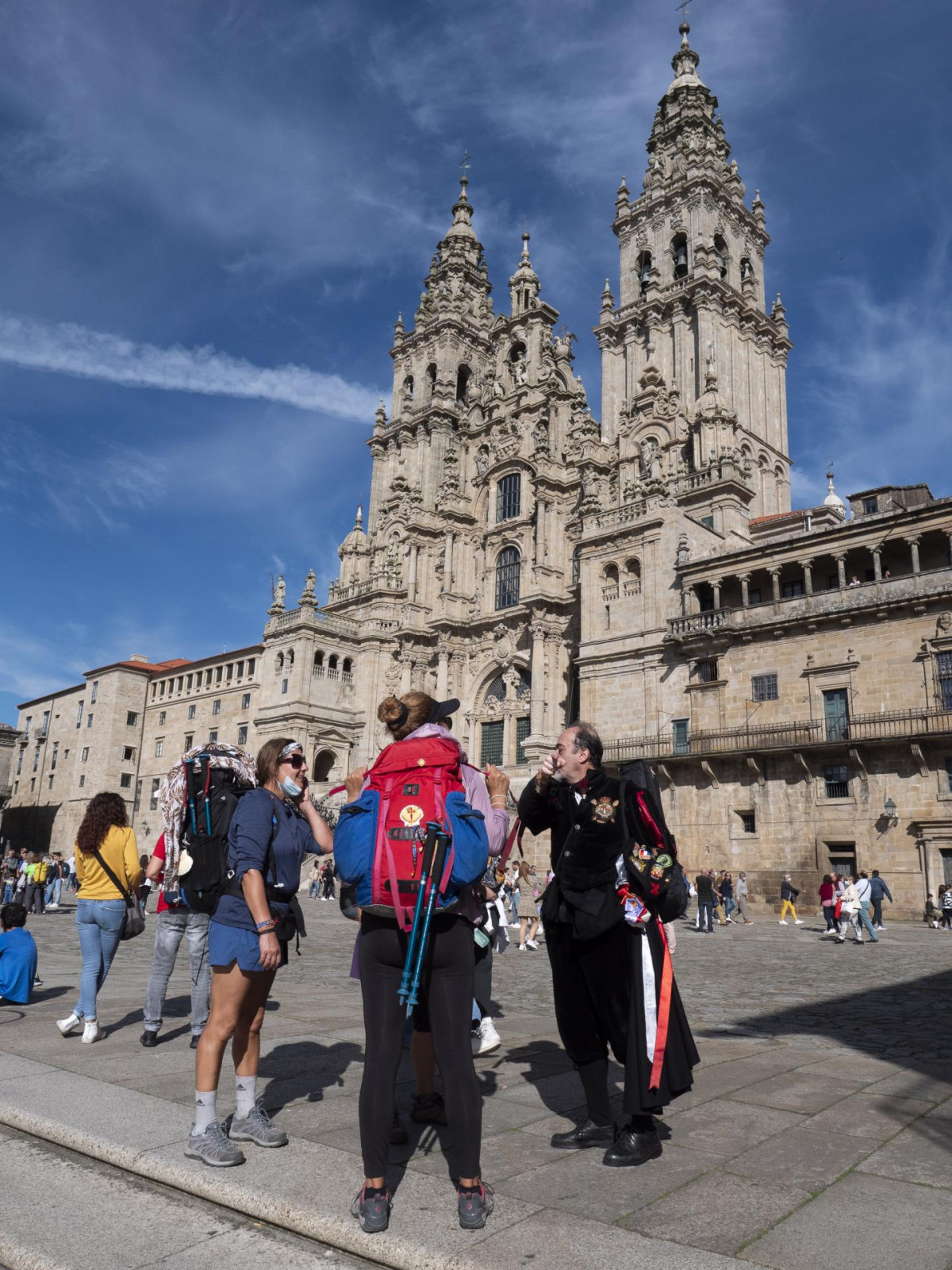 Un tuno habla con unas peregrinas en la plaza del Obradoiro, a 9 de octubre de 2021, en Santiago de Compostela, A Coruña, Galicia (España). Galicia amplía desde este sábado el aforo en interiores,
