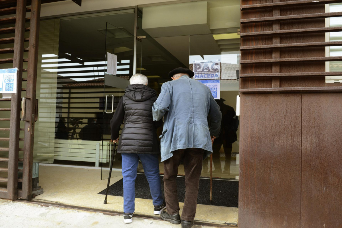 Comienza la campaña de vacunación simultánea contra la gripe y la tercera dosis de la Covid en mayores de 80 años. Dos personas acuden a un centro sanitario en Ourense a vacunarse.