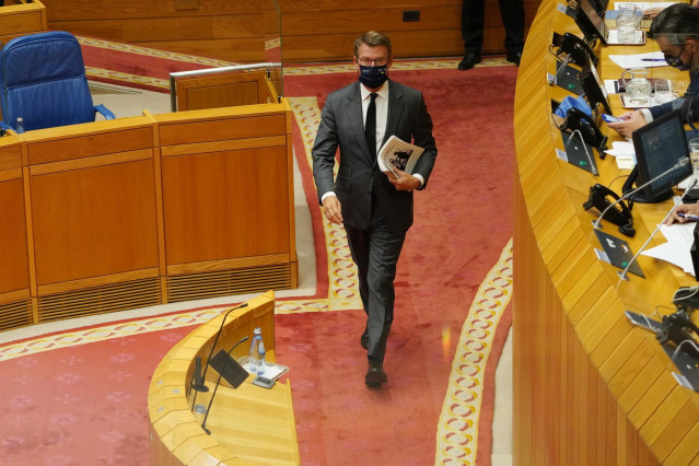 El presidente de la Xunta, Alberto Núñez Feijóo, se encamina a la tribuna para iniciar el Debate sobre el Estado de la Autonomía de octubre de 2021. En la portada, una imagen con el conselleiro de Facenda fallecido repentinamente.