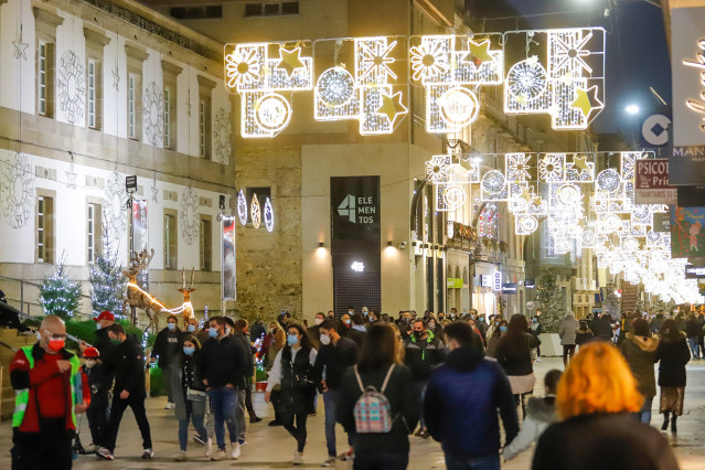 Archivo - Transeúntes pasean bajo las luces navideñas, en Vigo, Galicia (España), a 25 de diciembre de 2020.