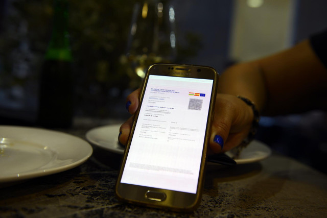 Archivo - Certificado digital de vacunación de una clienta de La Rioja en el casco histórico de Orense, a 24 de julio de 2021