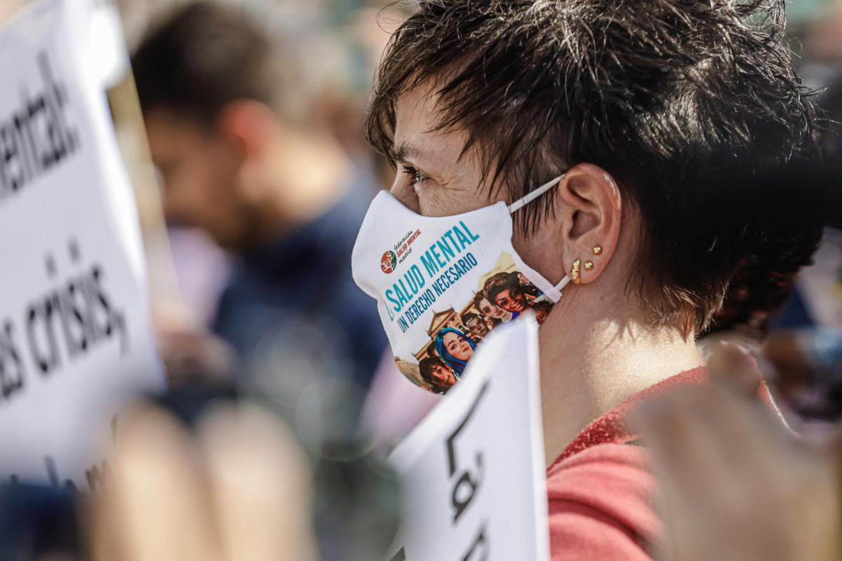 Archivo - Una mujer lleva una mascarilla donde se lee "Salud mental. Un derecho necesario", en una marcha con motivo del Día Mundial de la Salud Mental, a 10 de octubre de 2021, en Madrid (España).