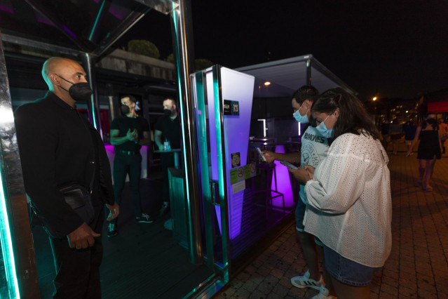 Archivo - Personas esperan para poder acceder a un local en Sanxenxo