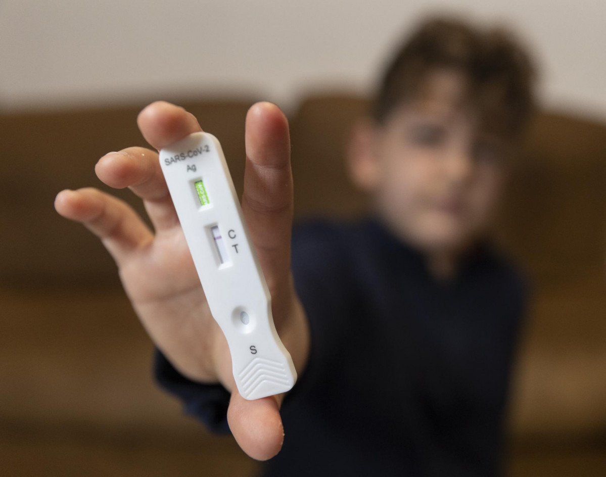 Un niño enseña un test de antígenos, a 16 de enero de 2022, en Madrid, (España). El Boletín Oficial del Estado (BOE) ha publicado el acuerdo de la Comisión Interministerial de Precios de los Med