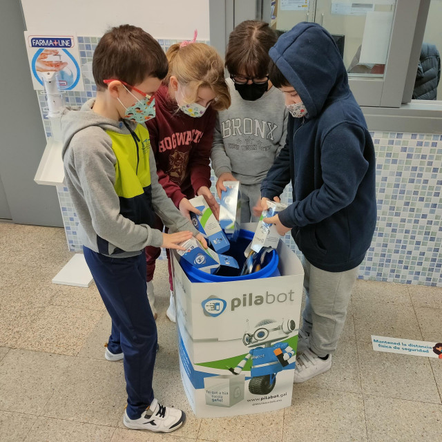 Niños reciclando pilas.