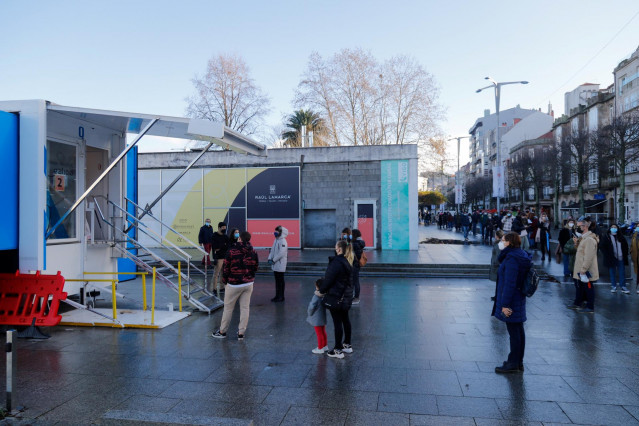 Archivo - Varias personas hacen cola para hacerse PCR, en un punto móvil de PCR gratuitas en el Naútico de Vigo en diciembre de 2021.