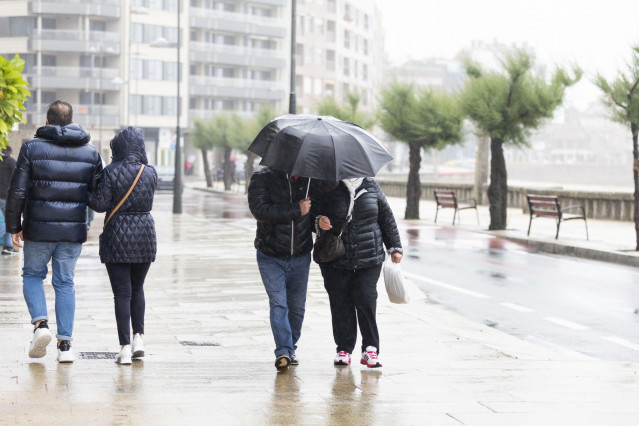 Archivo - Una pareja camina por una vía de Sanxenxo durante la celebración de un puente de las Letras Galegas pasado por agua, a 15 de mayo de 2021, en Sanxenxo, Pontevedra, Galicia, (España). Este evento, marcado por la reciente salida del estado de alar