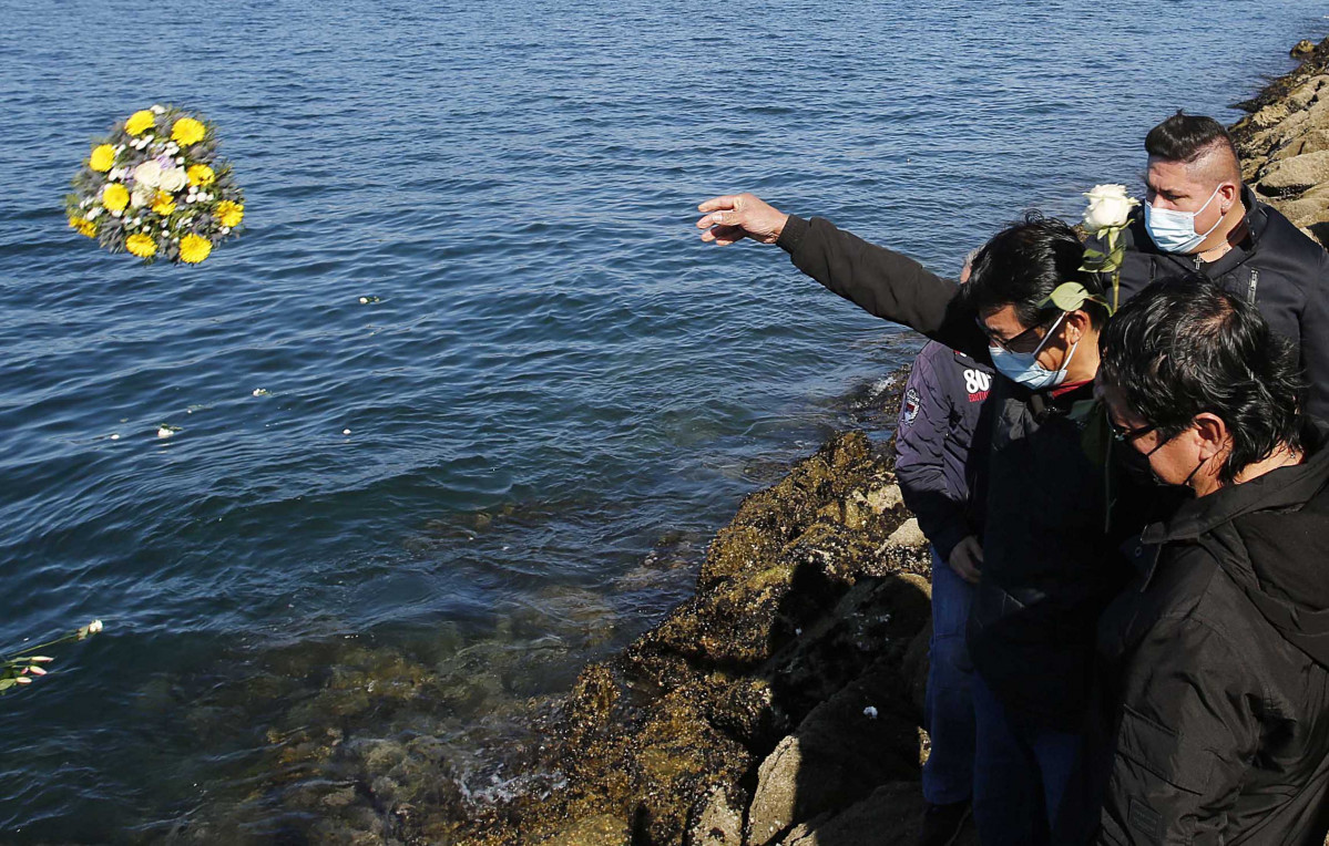 Un hombre lanza flores al mar en recuerdo a los tripulantes del pesquero gallego hundido en Terranova, a 19 de febrero de 2022, en Vigo, Galicia (España). El 'Villa de Pitanxo' naufragó de madrugada