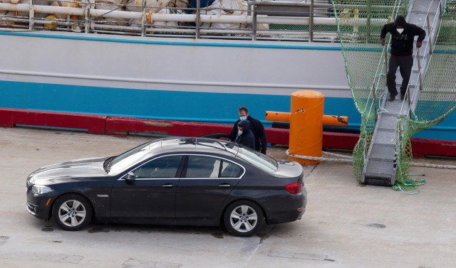 (I-D) El patrón, Juan Padín; su sobrino, Eduardo Rial Padín; y Samuel Kwesi, tripulantes del pesquero gallego que naufragó en aguas canadienses, se introducen en un vehículo tras bajar del pesquero español 'Playa Menduiña Dos' a su llegada al Puerto de Sa