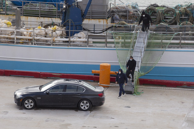 (I-D) El patrón, Juan Padín; su sobrino, Eduardo Rial Padín; y Samuel Kwesi, tripulantes del pesquero gallego que naufragó en aguas canadienses, bajan del pesquero español 'Playa Menduiña Dos' a su llegada al Puerto de San Juan de Terranova, a 19 de febre