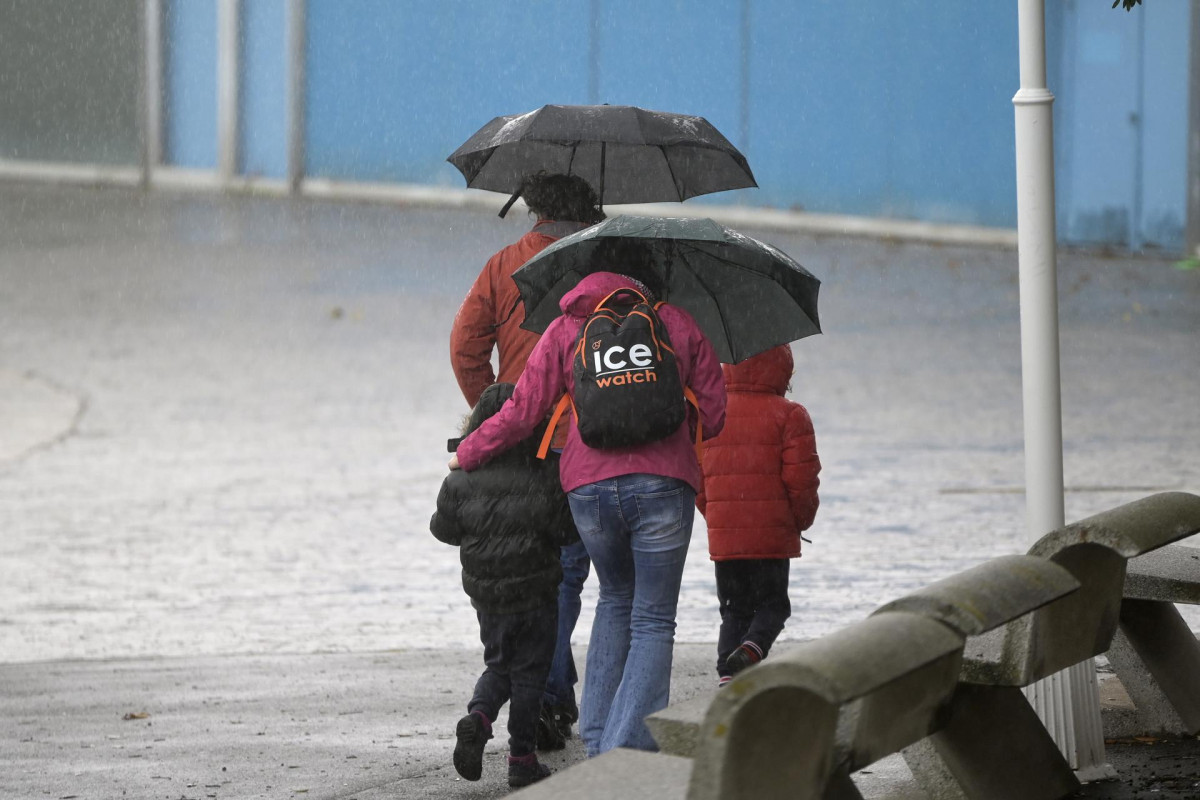 Archivo - Un grupo de personas camina por el paseo marítimo mientras llueve, a 8 de diciembre de 2021, en A Coruña, Galicia, (España). La borrasca Barra ha hecho que la Xunta haya activado para tod