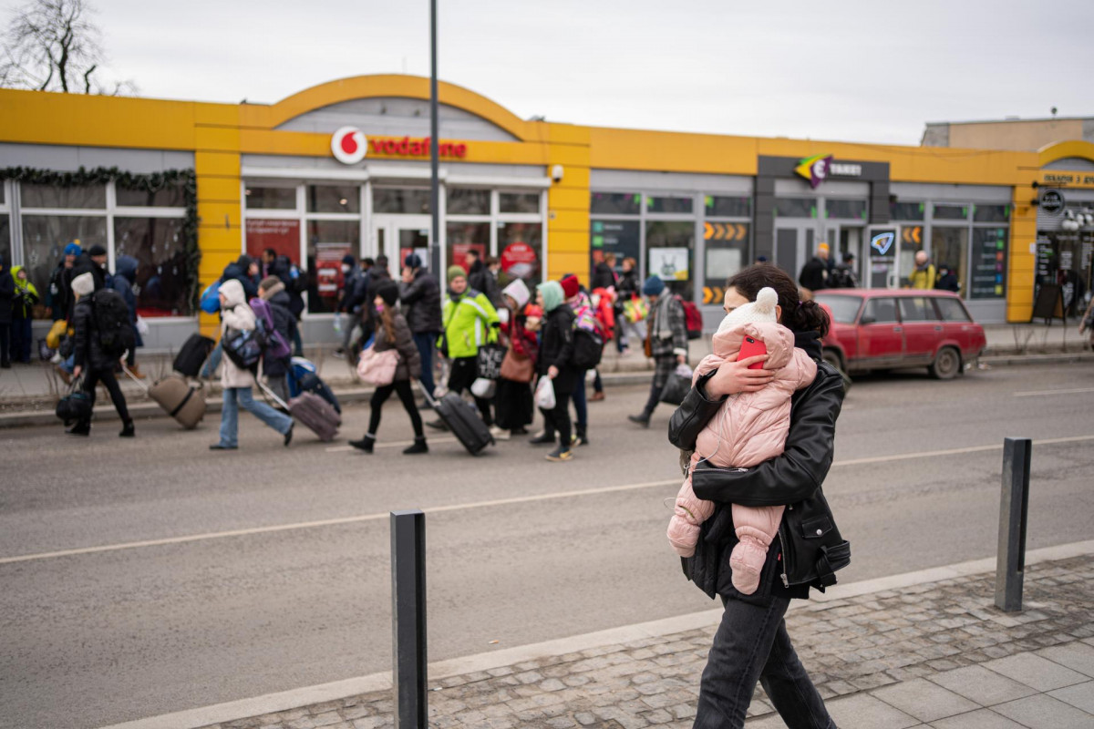 Una mujer camina y abraza a su bebé mientras suenan las sirenas antiaéreas en Lviv, a 2 de marzo de 2022, en Lviv (Ucrania)
