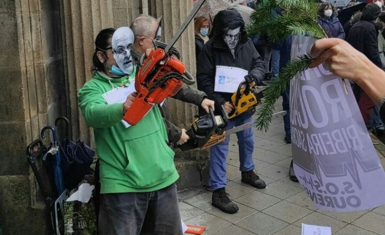Máscaras de Baltar y Feijóo, motosierra en mano, para protestar por la tala ilegal en San Pedro de Rocas​