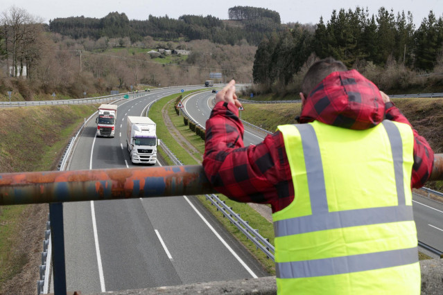 Un miembro de un piquete insulta y hace gestos a los camiones que pasan en dirección A Coruña escoltados por la Guardia Civil, durante el cuarto día de paros en el sector de los transportes, a 17 de marzo de 2022, en Baralla, Lugo, Galicia (España). Los t
