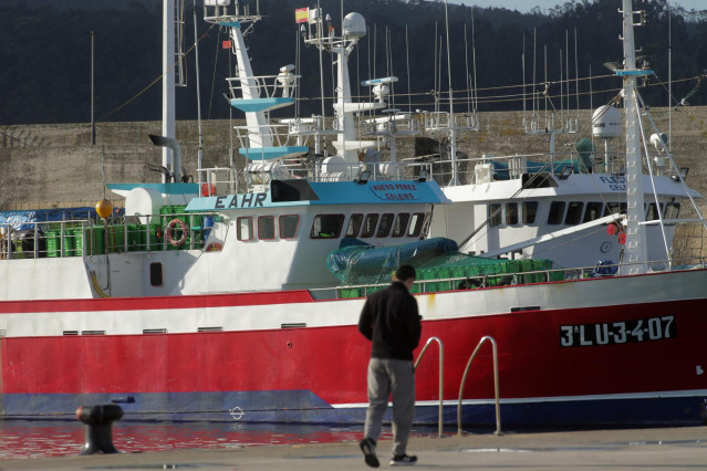 Una persona camina por el puerto de Celeiro, a 8 de marzo de 2022, en Viveiro, Lugo, Galicia (España). La flota de Celeiro, en el municipio lucense de Viveiro, ha iniciado un amarre parcial debido a la subida del precio del gasoil derivada de la guerra de