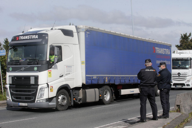 Dos agentes de Policía Nacional observan los camiones parados en el arcén en uno de los accesos al Polígono de O CEAO, en una huelga indefinida del transporte de mercancías, a 14 de marzo de 2022, en Lugo, Pontevedra (España). El paro, convocado a nivel n