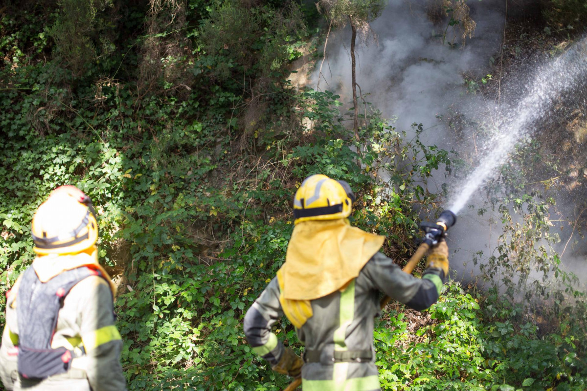 Archivo - Dos bomberos en un incendio forestal en la parroquia de Cubilledo, en el municipio de Baleira, comarca de A Fonsagrada, a 18 de agosto de 2021, en Lugo, Galicia (España). Según la Conselle