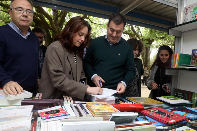 El conselleiro de Cultura, Román Rodríguez, acompañado por el secretario xeral de Política Lingüística, Valentín García; y el alcalde de Santiago, Xosé Sánchez Bugallo, en la inauguración de la Feria del Libro en Santiago de Compostela.