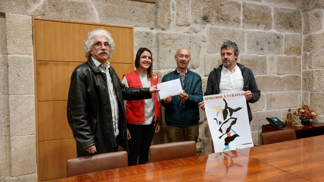 El pintor Baldomero Moreiras hace entrega a responsables de la Cruz Roja de Ourense lo recaudado en apoyo a Ucrania, ante el alcalde de Celanova, Antonio Puga.