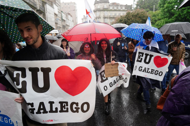Varias personas con paraguas y carteles en los que se lee: 'Eu O Galego (hablo gallego)', participan en una manifestación, bajo el lema: ‘Queremos Galego’, a 17 de mayo de 2022, en Santiago de Compostela, A Coruña, Galicia (España). La protesta se celebra