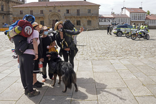 Archivo - Varios peregrinos se toman una foto, a su llegada a la Catedral de Santiago.