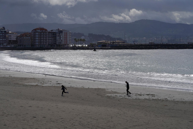Varias personas pasean por la playa de Silgar en Sanxenxo