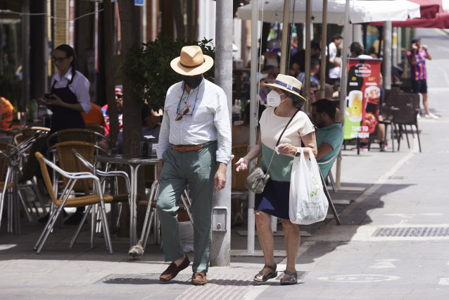 Una pareja, con sombreros, se protegen del Sol durante el primer día de altas temperaturas en Sevilla, a 19 de mayo de 2022 en Sevilla (Andalucía, España)
