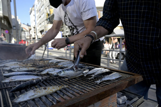 Archivo - Dos hombres asan sardinas por la festividad de San Juan, a 23 de junio de 2021, en A Coruña, Galicia (España).