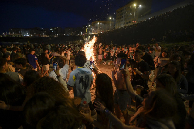 Centenares de personas frente a una hoguera en la Noche de San Juan, a 23 de junio de 2022, en A Coruña, Galicia (España).