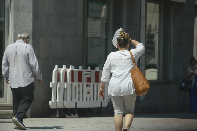 Dos personas caminan por una vía en plena ola de calor, a 12 de julio de 2022, en Orense, Galicia (España).