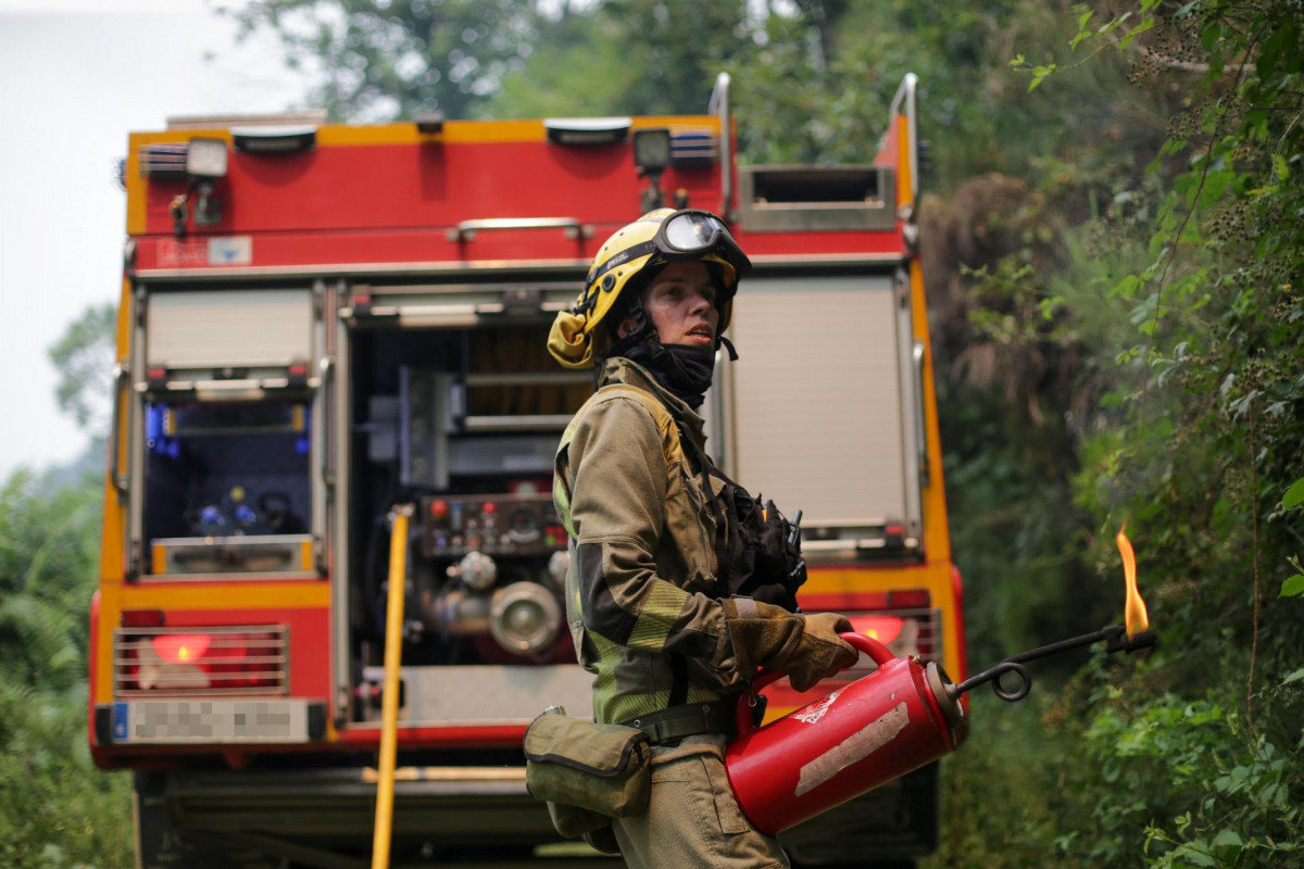 Agente de las Brigadas de Refuerzo en Incendios Forestales (BRIF) realiza labores de extinción durante un incendio, a 15 de julio de 2022, en Samos.