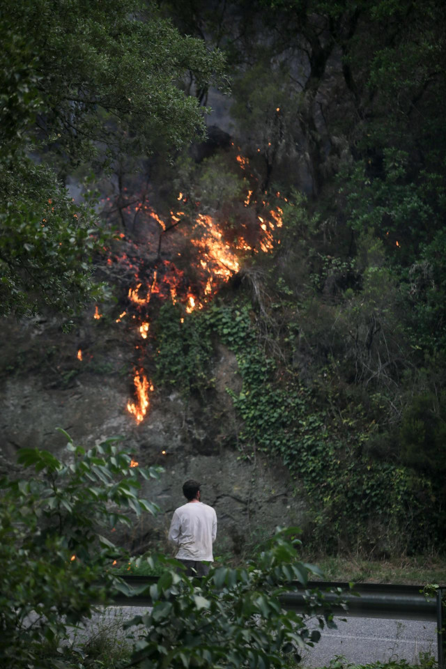 Un hombre observa un incendio, a 15 de julio de 2022, en Quiroga, Lugo, Galicia (España). Permanece activo desde las 20,29 horas de este jueves un incendio en la parroquia de Outeiro, que según las últimas estimaciones afecta a una superficie de 200 hectá
