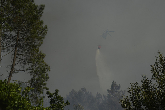 Un helicóptero trabaja en la extinción de un incendio, a 27 de julio de 2022, en Castrelo de Miño, Ourense, Galicia (España). El incendio forestal ha quemado unas seis hectáreas, según estimación provisional de Medio Rural. La Consellería informa que el f