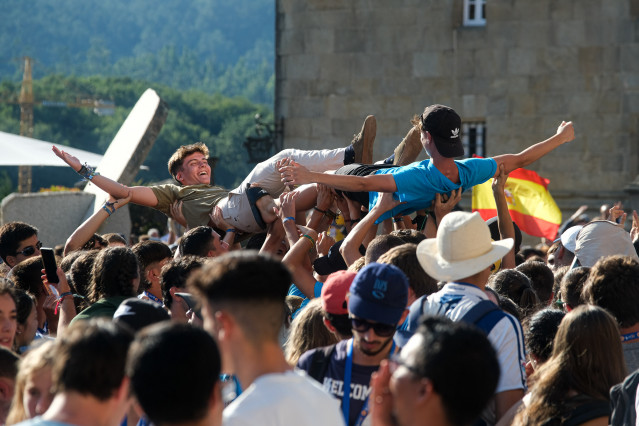 Dos jóvenes son levantados en brazos durante la inauguración y acto de acogida de la peregrinación europea de jóvenes 2022, en el Obradoiro de Santiago, a 3 de agosto de 2022, en Santiago de Compostela, A Coruña, Galicia (España). La Peregrinación Europea
