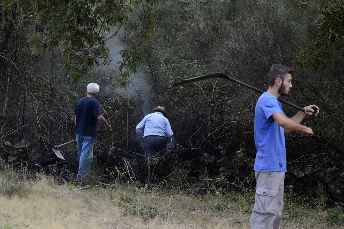 Varias personas trabajan en la extinción de las llamas del incendio, a 10 de agosto de 2022, en Laza, Ourense, Galicia (España). Según la última actualización provisional de la Consellería de Me