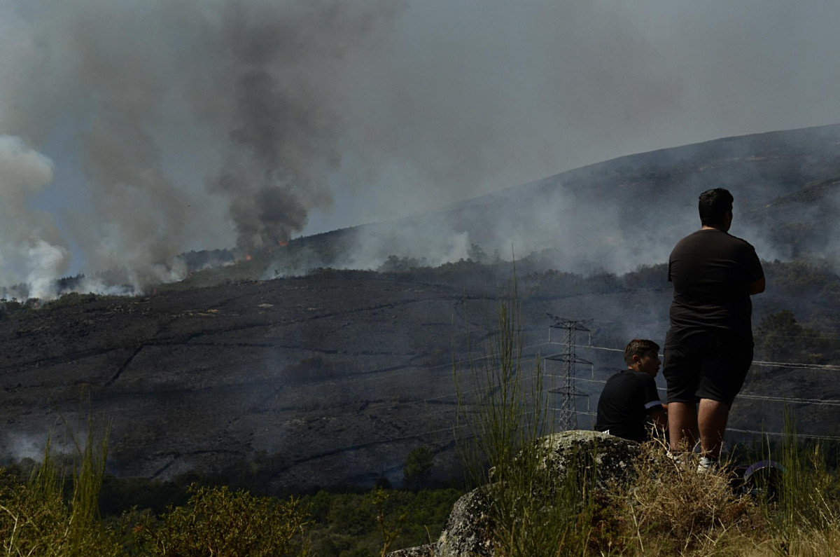 Dos personas de Grou observan el incendio forestal en la Serra do Leboreiro, en Senderiz, en el parque natural de Baixa Limia e Serra do Xurés, a 26 de agosto de 2022, en Serra do Xurés, Ourense, Ga
