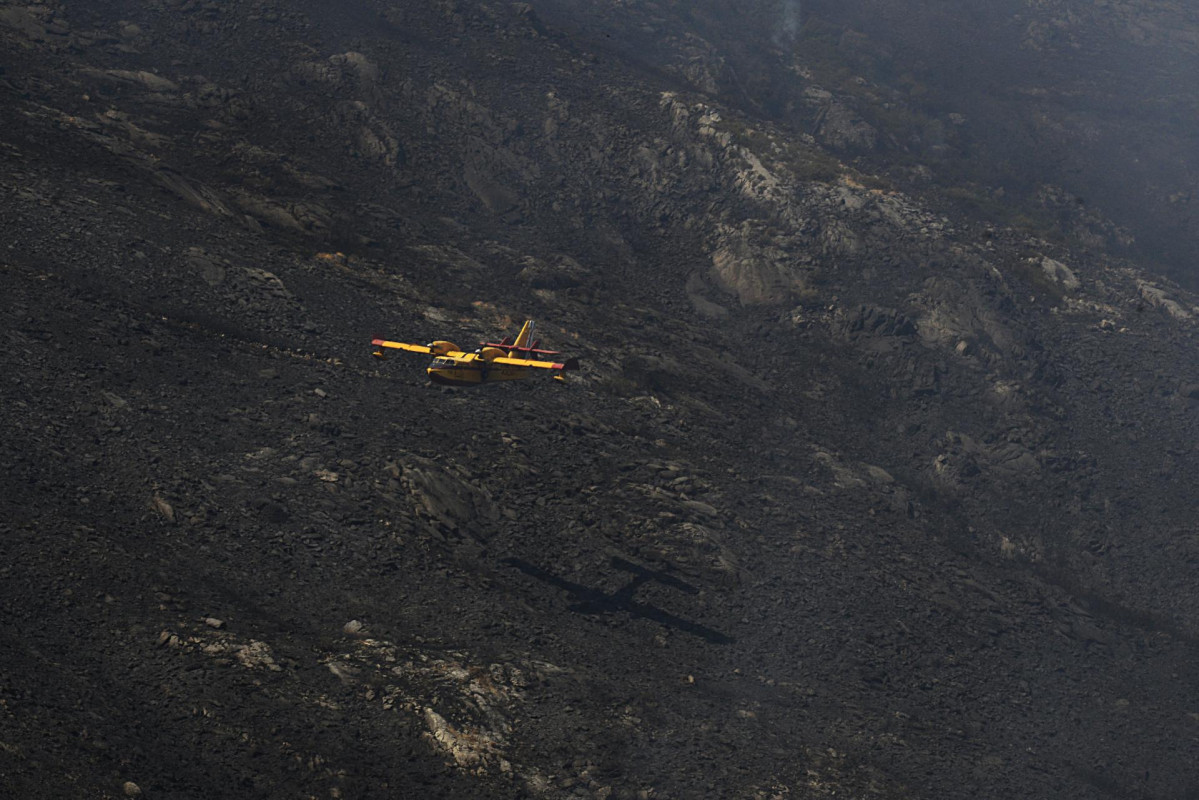 Un hidroavión trabaja en las labores de extinción en un incendio en la Serra do Leboreiro, en los montes del pueblo de Senderiz, en el parque natural de Baixa Limia e Serra do Xurés, a 26 de agosto