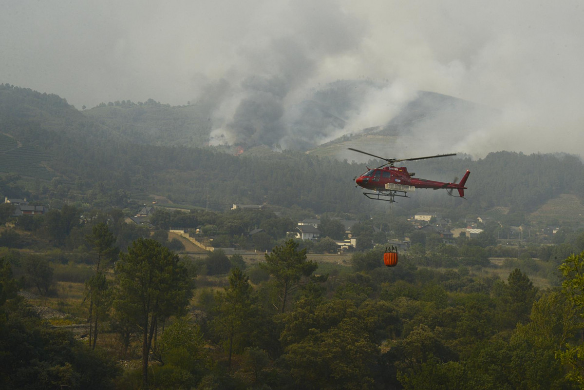 Archivo - Un helicóptero trabaja en la extinción del incendio, a 18 de julio de 2022, en O Barco, en una foto de archivo.