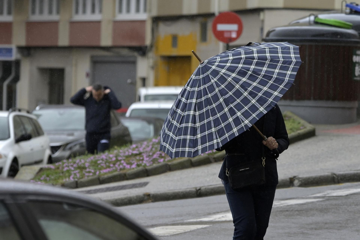 Archivo - Una persona con paraguas camina por el centro de A Coruña