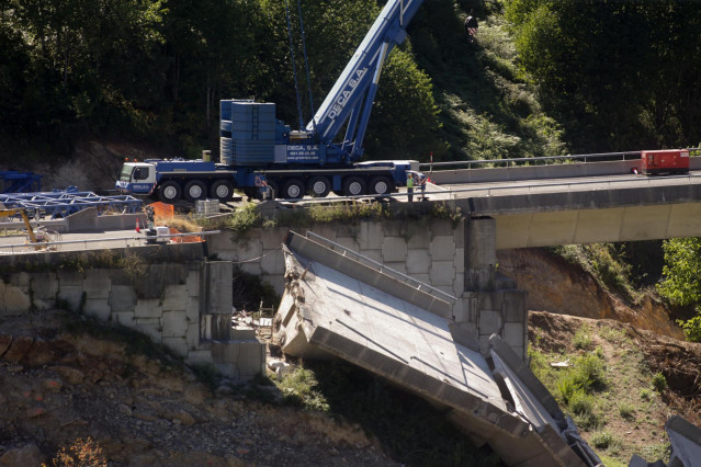 Operarios y grúas trabajan durante el desmontaje del tercer y último vano del viaducto de la A6, a 19 de agosto de 2022, en Vega de Valcarce, León, Castilla y León, (España).