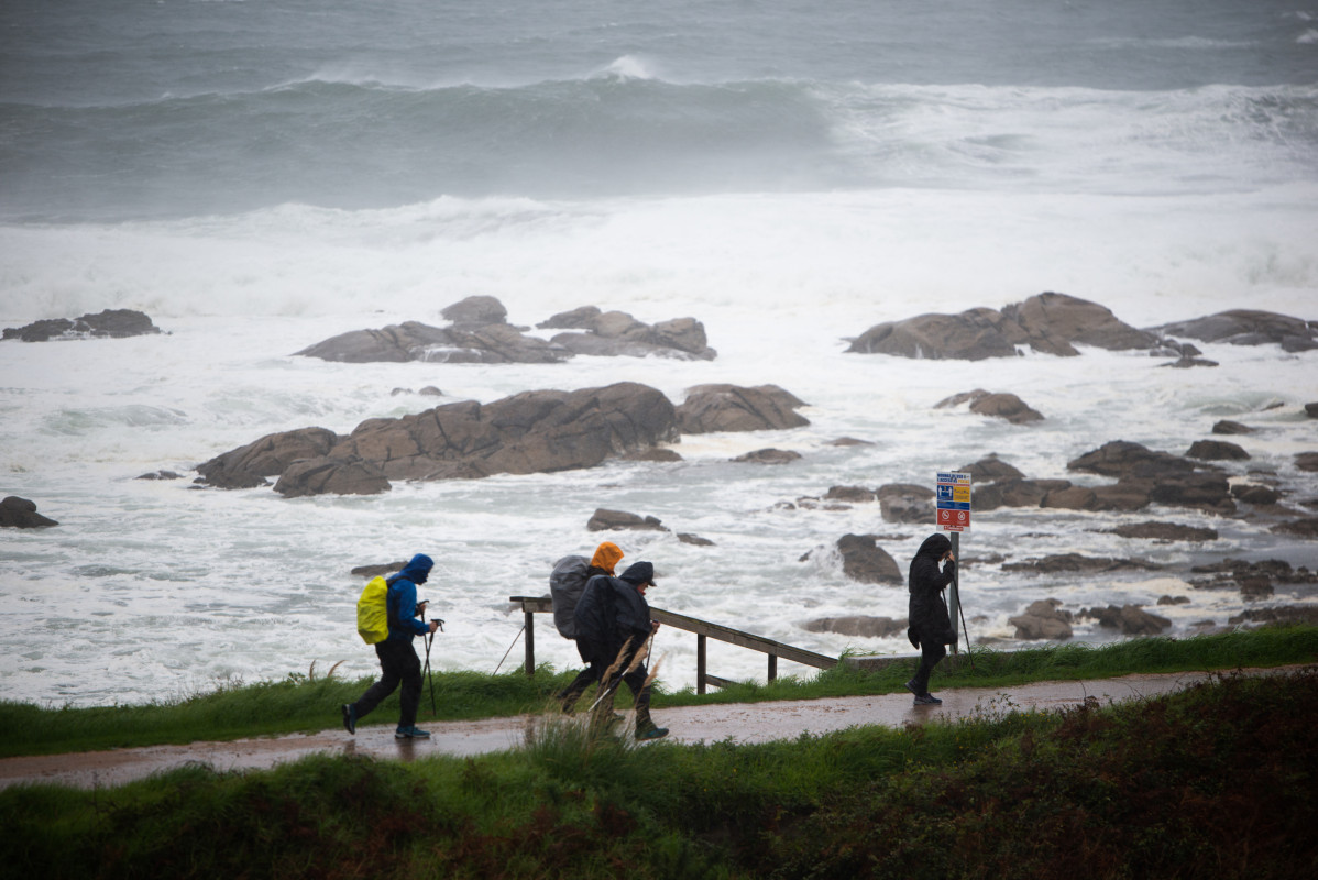 Varios peregrinos realizan el Camino de Santiago, a pesar del temporal, en la zona de Santa Maria de Oia hasta Cabo Silleiro, a 20 de octubre de 2022, en Pontevedra, Galicia, (España). La borrasca Ar