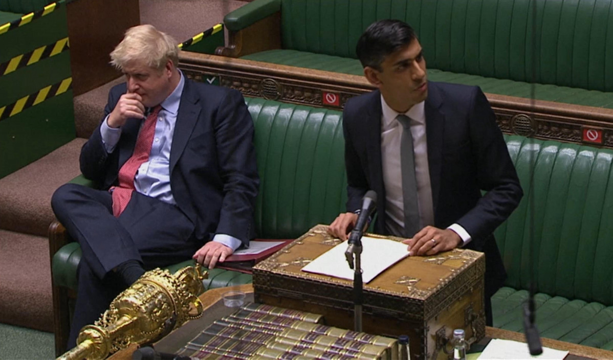 El primer ministro británico,Boris Johnson, sentado al lado del ministro de Finanzas, Rishsi Sunak