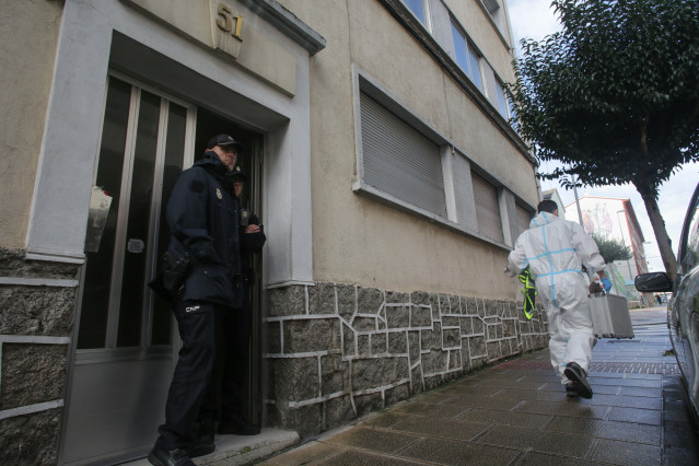 Un agente de Policía Nacional en la puerta de la vivienda donde han hallado muerta a una mujer de 42 años.