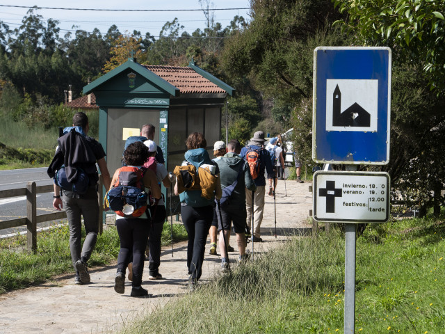 Archivo - Un grupo de peregrinos pasa frente a un cartel que indica el horario de misas mientras realizan el Camino de Santiago, en Santiago de Compostela, a 9 de octubre de 2021, en Santiago de Compostela, A Coruña, Galicia (España). Galicia amplía desde