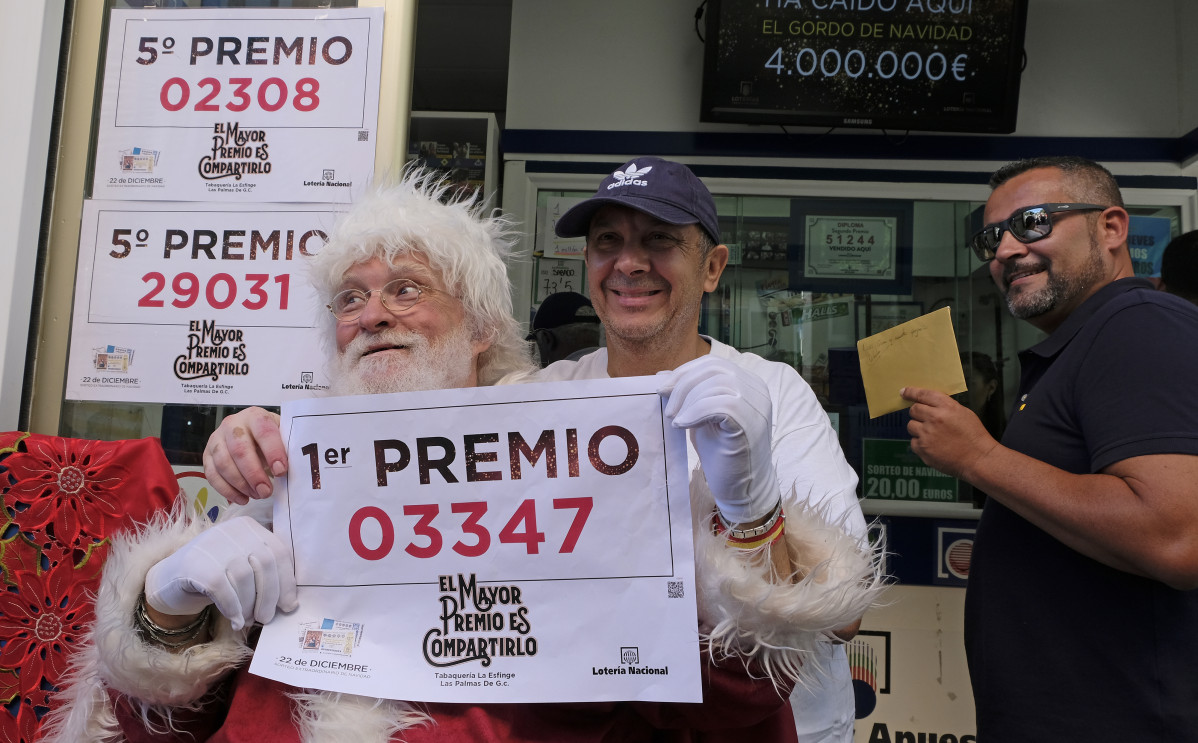 El propietario (con gorra) de la administración de Loteria La Esfinge, de calle Ripoche n1 de Las Palmas de Gran Canaria, celebra, con algunos de los agraciados, que ha repartido parte del Gordo y el quinto premio del Sorteo de Lotería Nacional.