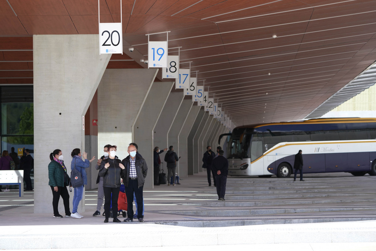 Archivo - Varias personas esperan autobuses desde una de las dársenas de la nueva estación de autobuses de Santiago de Compostela, a 22 de abril de 2021, en Santiago de Compostela, Galicia.